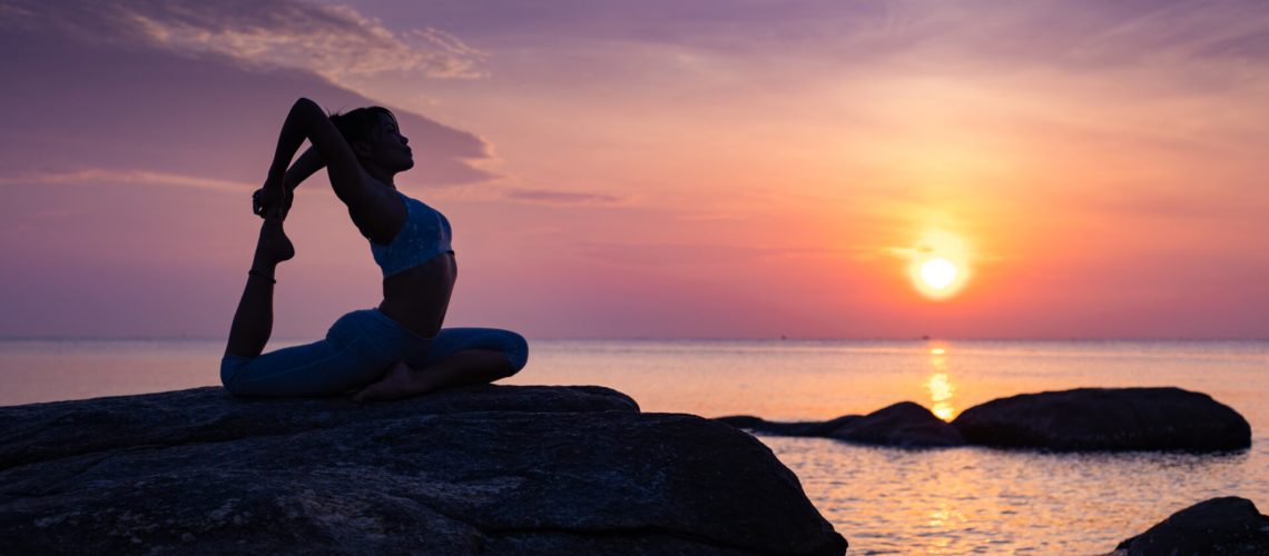 Asian girl practice Yoga on the beach Sunrise morning day